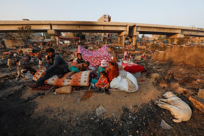 Slum dwellers return to their homes after a fire in Pakistan's southern city of Karachi. Reuters