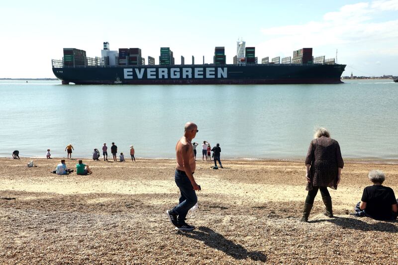 Spectators watch the ship arrive in port from the beach in Felixstowe.