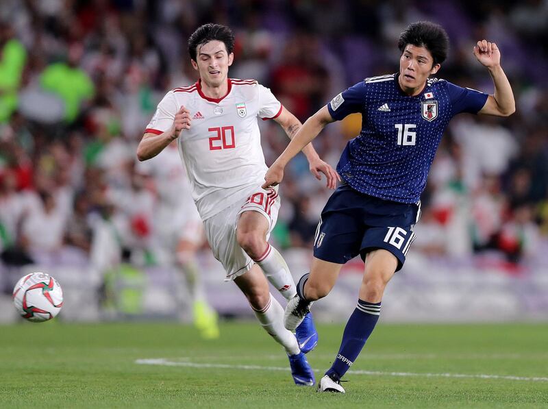 Al Ain, United Arab Emirates - January 28, 2019: Takehiro Tomiyasu of Japan and Sardar Azmoun of Iran during the semi final of the Asian Cup 2019. Monday, January 28th, 2019 at Hazza Bin Zayed Stadium, Al Ain. Chris Whiteoak/The National