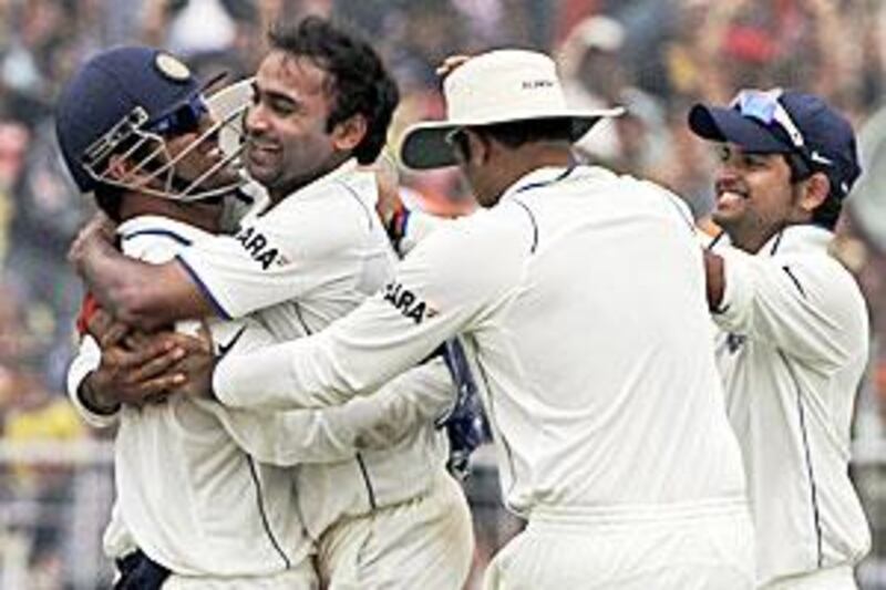 Amit Mishra is congratulated by captain Dhoni, left, and other teammates after the dismissal of Graeme Smith at the Eden Gardens.