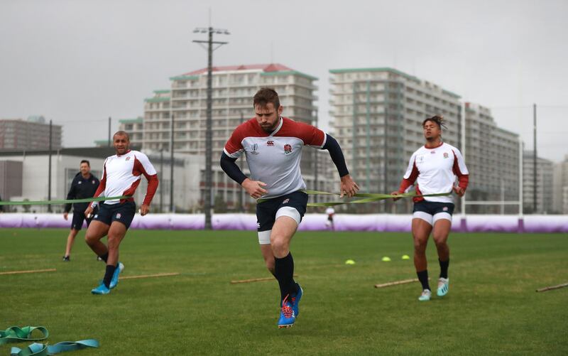 Elliot Daly using a resistance band held by England team mate Anthony Watson. Getty