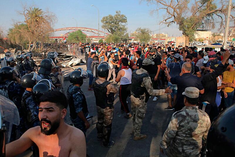 Security forces try to prevent protesters from breaking into government buildings. AP