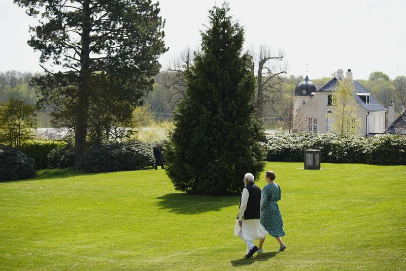 Ms Frederiksen and Mr Modi talk as they walk through the garden of the Danish leader's official residence. AFP