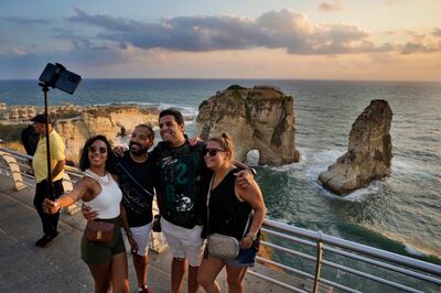 Tourists take a selfie in front of Raouche Rock as the sun sets over the Mediterranean in Beirut. AP