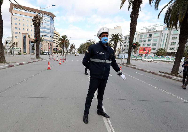 epa08937169 A Tunisian policeman stands guard amid a lockdown due to the Covid-19 pandemic in Tunis, Tunisa, 14 January 2021. Tunisia on 14 January is marking the 10th anniversary of popular uprising that ousted former president Zine El Abidine Ben Ali.  EPA/MOHAMED MESSARA