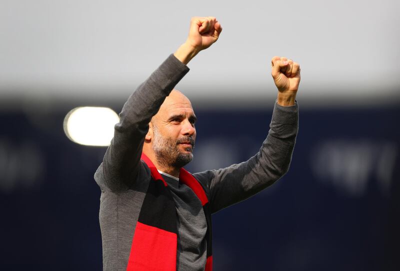 Pep Guardiola, manager of Manchester City, celebrates whilst wearing a black and red scarf in memory of former club secretary Bernard Halford. Getty Images