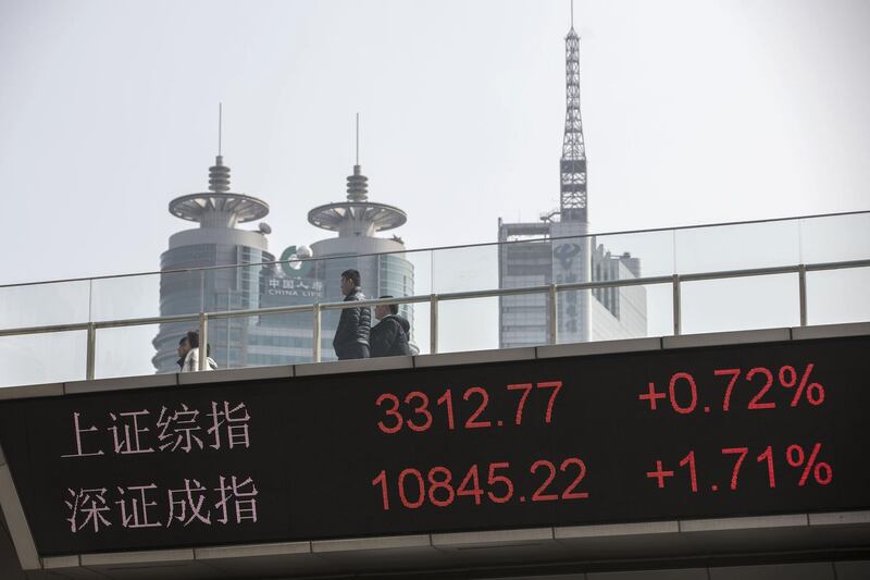 People walk along an elevated walkway as an electronic ticker displays the figures of the Shanghai Composite Index, top, and the SZSE Component Index in the Lujiazui Financial District in Shanghai, China, on Monday, Feb. 26, 2018. Xi Jinping's decision to cast aside China's presidential term limits is stoking concern he also intends to shun international rules on trade and finance, even as he champions them on the world stage. Photographer: Qilai Shen/Bloomberg