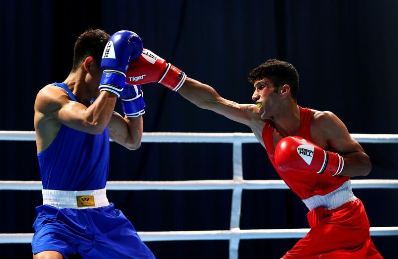 Marvin Tabamo of Philippines (blue) blocks a punch from Ramish of Afghanistan (red) in a men's flyweight 52kg preliminary bout on day one of the Asian Boxing Championships in Dubai. Getty Images