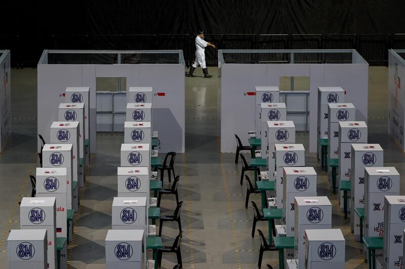 A member of a disinfection team walks along swabbing booths at a testing center for COVID-19 disease at the SM MOA Arena in Manila, Philippines. EPA