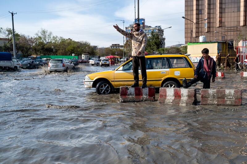 A policeman directs traffic during floods in Kabul, Afghanistan. AFP