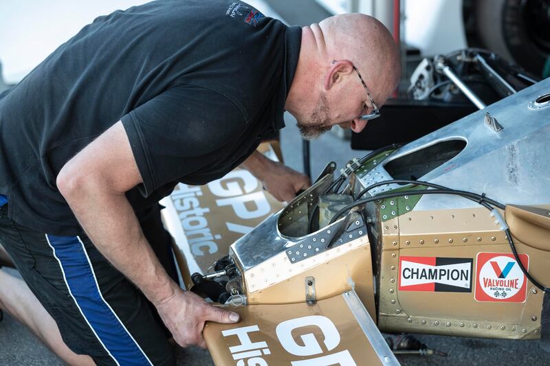 A mechanic from the Arrows A3 team fits the front scoop of their race car