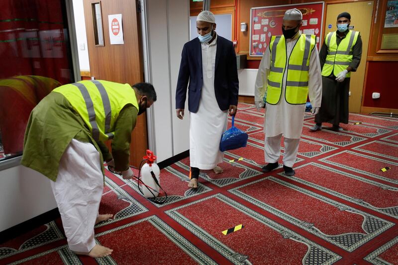 The communal areas are disinfected between prayer sessions, at Minhaj-ul-Quran Mosque, at the start of Eid al-Adha, in London, Friday, July 31, 2020. Britain’s health secretary is defending the government’s abrupt re-imposition of restrictions on social life across a swath of northern England. Matt Hancock says it's important to clamp down quickly on new outbreaks of COVID-19. The affected region has a large Muslim population, and the restrictions come prior to the Eid al-Adha holiday starting on Friday. (AP Photo/Kirsty Wigglesworth)