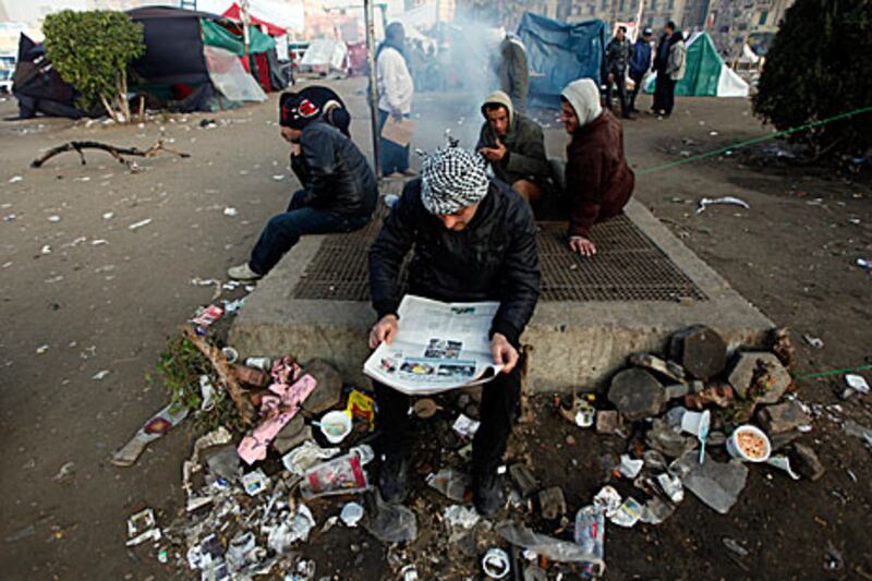 A protester in Tahrir Square reads a newspaper a day after Egypt's January 25 anniversary.