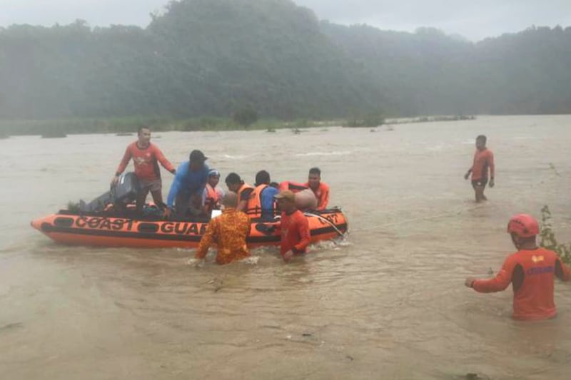 Rescuers use a rubber dinghy to evacuate quarry workers trapped in Naguilian, La Union province, Philippines. AP
