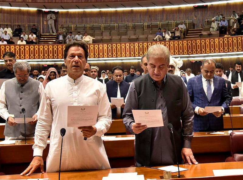 Newly elected Imran Khan, left, takes the oath of office with Shah Mehmood Qureshi, in Islamabad, Pakistan, on August 13. AP
