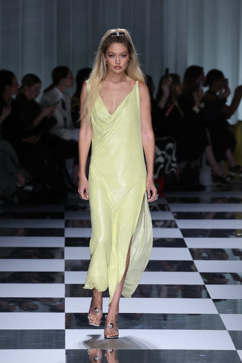 Gigi Hadid in a pale yellow shift dress at Versace. Getty Images