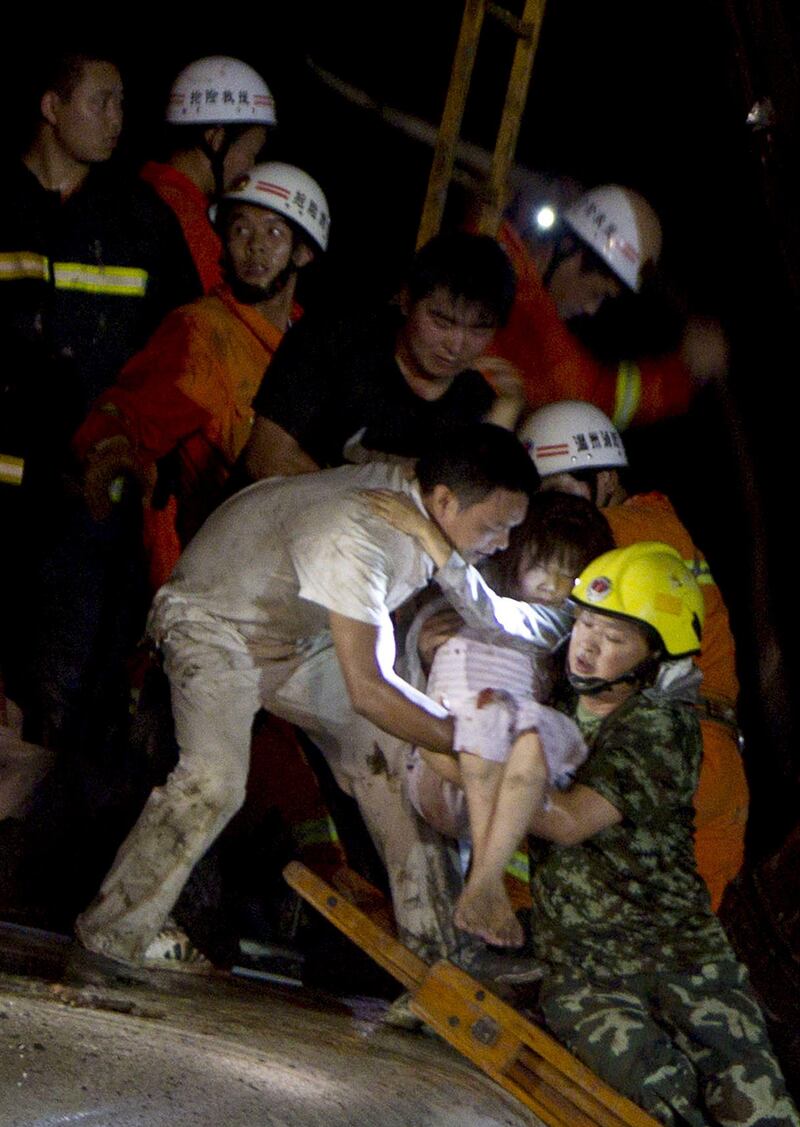 Chinese rescue workers carry an injured girl as they tend to the victims of a high-speed train accident on July 23, 2011, near Wenzhou. Two train cars derailed and fell off a bridge after the train, already crippled by a lightning strike, was hit from behind by another express, according to state media reports. The train, which was travelling between the eastern Chinese cities of Wenzhou and Hangzhou, went off the rails around 8:30pm (1230 GMT), Xinhua news agency reported, citing local firefighting sources. At least 11 people were killed. CHINA OUT AFP PHOTO
 *** Local Caption ***  478935-01-08.jpg