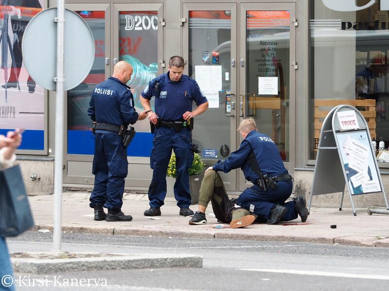 The suspect lies on the ground surrounded by police officers at the Market Square where several people were stabbed, in Turku, Finland. Courtesy Kirsi Kanerva /Handout via Reuters.