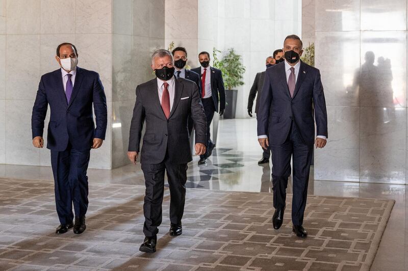 Jordan's King Abdullah II, centre, arrives with Egyptian President Abdel Fattah El Sisi, left, and Iraqi Prime Minister Mustafa Al Kadhimi, right, ahead of the summit in the capital Amman.  Jordanian Royal Palace / AFP Photo