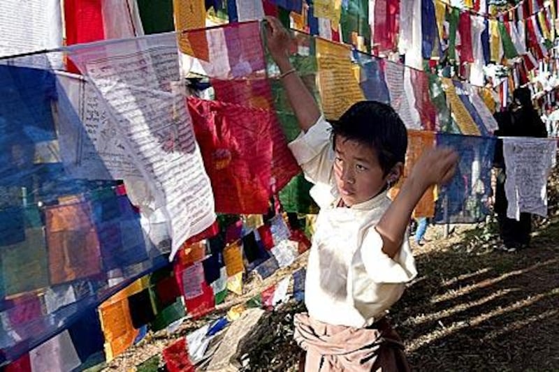 A Tibetan boy hangs prayer flags in Dharamsala.