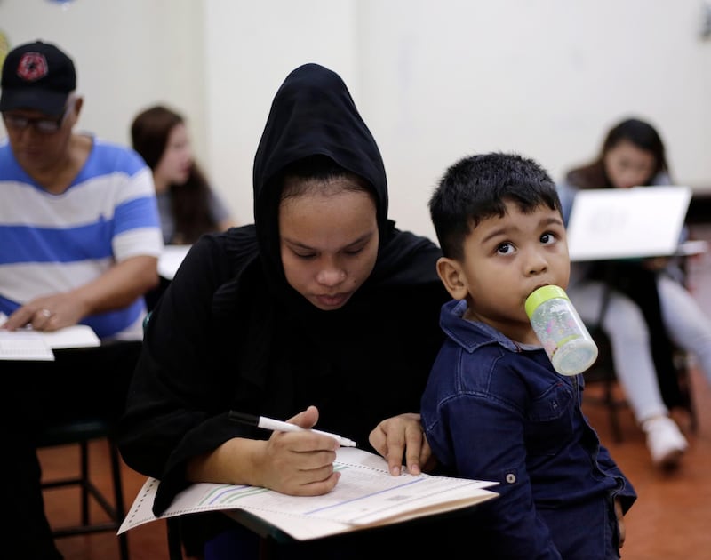 A Filipino Muslim mother fills out her ballot at an elementary school turned into a voting precinct in Manila, Philippines.  EPA