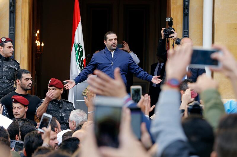 Lebanese Prime Minister Saad Hariri sings the Lebanese national anthem with thousands of his supporters who rallying outside his residence in Beirut, Lebanon, Wednesday, Nov. 22, 2017. Hariri said he was putting his resignation on hold responding to a request from the president to give more time to consultations. (AP Photo/Bilal Hussein)