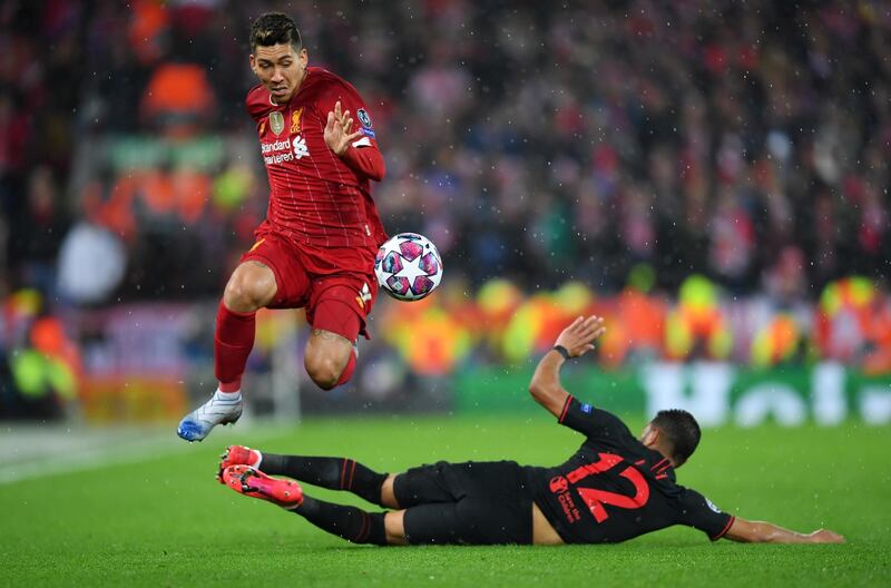 LIVERPOOL, ENGLAND - MARCH 11: Roberto Firmino of Liverpool is challenged by Renan Lodi of Atletico Madrid during the UEFA Champions League round of 16 second leg match between Liverpool FC and Atletico Madrid at Anfield on March 11, 2020 in Liverpool, United Kingdom.  (Photo by Laurence Griffiths/Getty Images)
