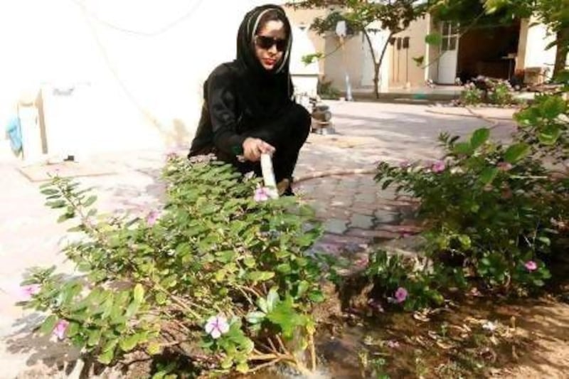 Manahel Mahmoud Bedah, an Emirati fashion designer, watering the plants.
