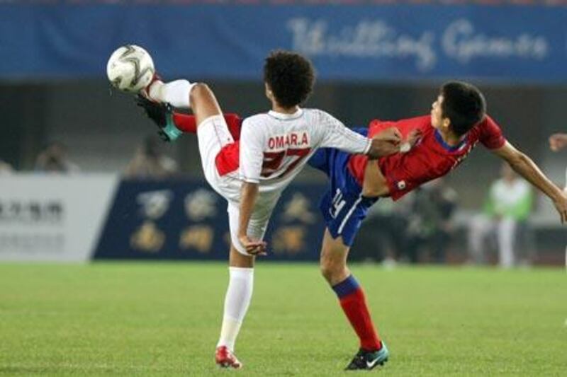 Omar Abdulrahman al-Amoudi (L) of United Arab Emirates fights for the ball with Kim Jung-Woo of South Korea during the men's semi-final match at the 16th Asian Games in Guangzhou on November 23, 2010.  AFP PHOTO