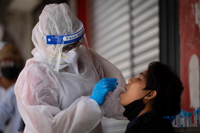 A doctor collects a sample for a coronavirus test outside a clinic in Kajang on the outskirts of Kuala Lumpur, Malaysia. AP Photo