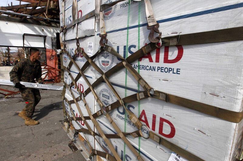 A US Marine carries a ladder while his colleagues unload boxes of relief goods in the super typhoon devastated city of  Tacloban, Leyte province, Philippines. Dennis M. Sabangan / EPA