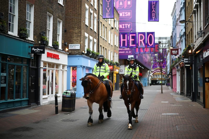 Mounted police on Carnaby Street patrol next to closed shops. Reuters