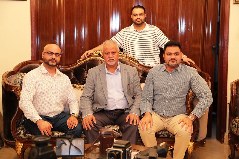 Shaukat with his sons Muhammad Ayub, left, Taimur Shaukat Ali Rana, right, and Muhammad Asad, standing, at his home in Mirdif. All photos: Pawan Singh / The National