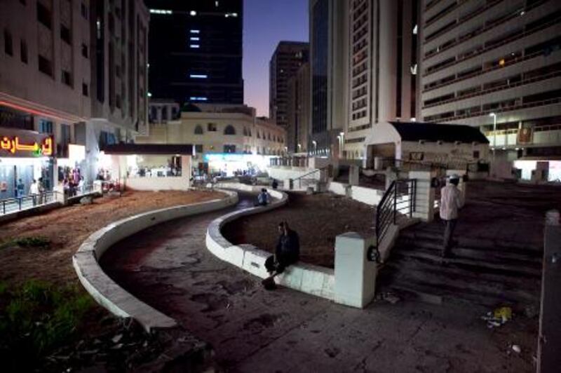 People walk through a half-demolished, half-rebuilt children's park, which sits on top of an underground parking garage surrounded on Tuesday evening, Nov. 9, 2011, in downtown Abu Dhabi. (Silvia Razgova/The National)
