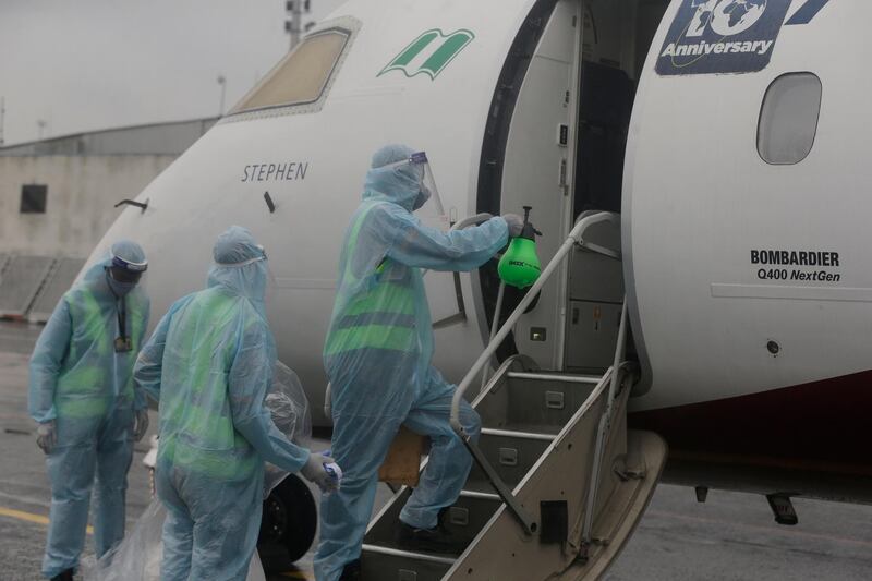 Cleaners wearing protective gear to protect against coronavirus sanitise the door of a plane upon its arrival from Abuja at the Murtala Mohammed Airport in Lagos. AP Photo