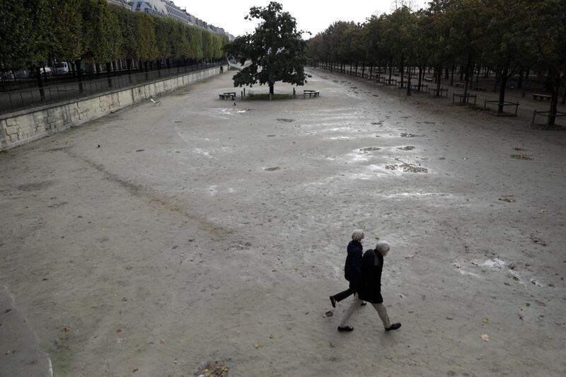 People walk in an empty Tuileries gardens in Paris, France. AP Photo