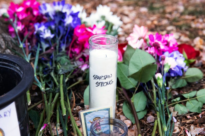 Flowers and a candle reading 'Spartan strong' outside the university's Berkey Hall. AP