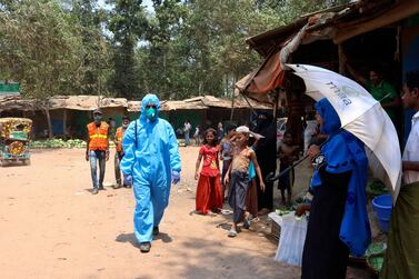 A health worker from an aid organisation walks wearing a hazmat suit at the Kutupalong Rohingya refugee camp in Cox's Bazar, Bangladesh. AP