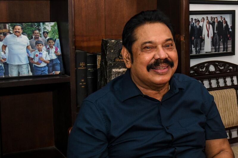 Prime Minister Mahinda Rajapaksa poses for photographs at his home in the southern town of Tangalle on August 7, 2020, after the Sri Lanka's parliamentary election results. Sri Lanka's ruling Rajapaksa brothers have secured a two-thirds majority in parliamentary elections, giving them powers to change the constitution and unravel democratic safeguards, final results showed on August 7. / AFP / LAKRUWAN WANNIARACHCHI
