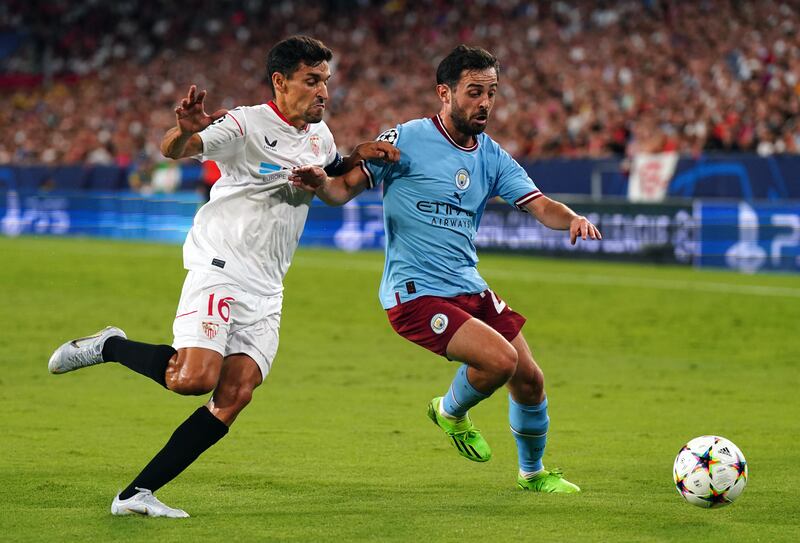 Sevilla's Jesus Navas (left) and Manchester City's Bernardo Silva battle for the ball during the UEFA Champions League Group G match at the Ramon Sanchez Pizjuan Stadium in Seville, Spain. Picture date: Tuesday September 6, 2022.