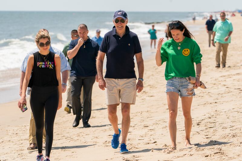 Mr Biden walks on the beach with granddaughter Natalie and daughter Ashley in Rehoboth Beach, Delaware. AP