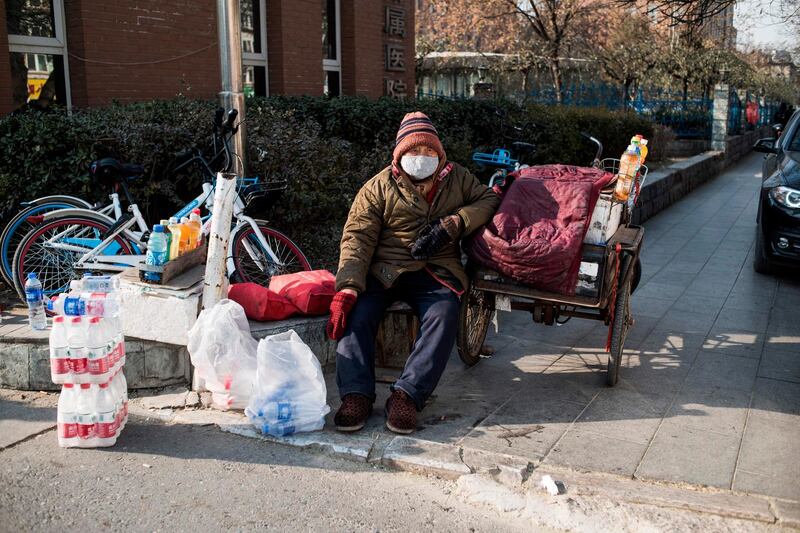 In this picture taken on December 13, 2017, a man sells goods near the hospital on a cold day in Baoding.
As temperatures dipped below freezing in a northern Chinese village, a group of parka-clad women tried to stay warm as they played mahjong around a small gas stove in a grocery store. / AFP PHOTO / FRED DUFOUR / To go with AFP story China-Energy-Pollution , Focus by Julien Girault