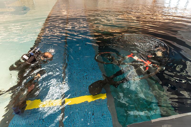 Mr Lundgren and Mr Farooq begin the process of placing a bicycle in the pool. 
