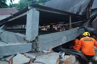 Indonesian rescuers look for survivors in a collapsed building in Mamuju after a 6.2-magnitude earthquake rocked Sulawesi island. National Search and Rescue Agency / AFP