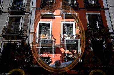 This picture taken on September 25, 2018 shows signs reading "For sale" hanging from balcony and reflected on a miror in a shop in Madrid. Capsule flats, price rises forcing tenants out: rents in Spain are soaring post-crisis, fuelling concerns of a new "bubble" in a country still traumatised by the collapse of its housing sector. / AFP / GABRIEL BOUYS                    
