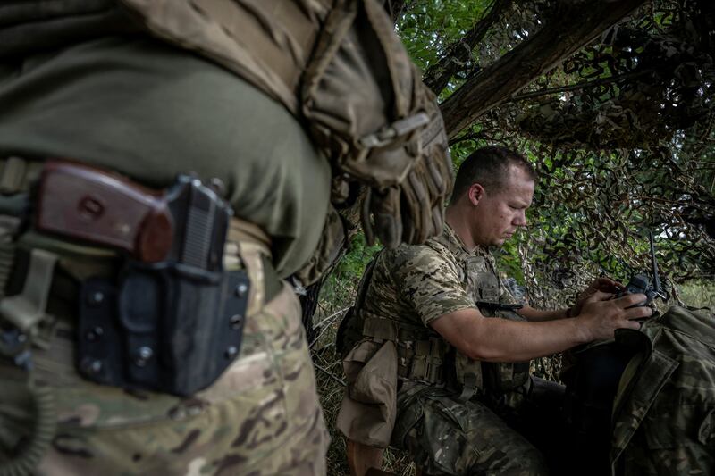 A Ukrainian serviceman operates an FPV drone from the front line