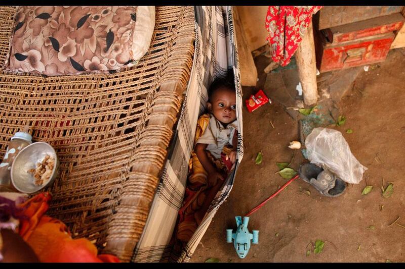 A boy lies in a baby hammock in his family's hut in the Akhdam community in Yemen's western port city of Houdieda.