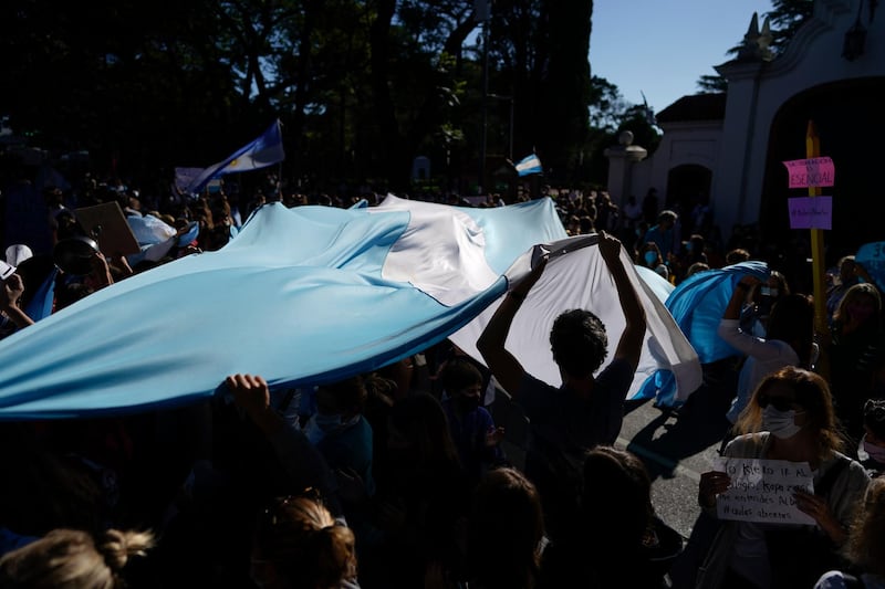 People wave an Argentine flag outside the presidential residence as they protest for in-person classes amid the Covid-19 pandemic in Buenos Aires. AP Photo