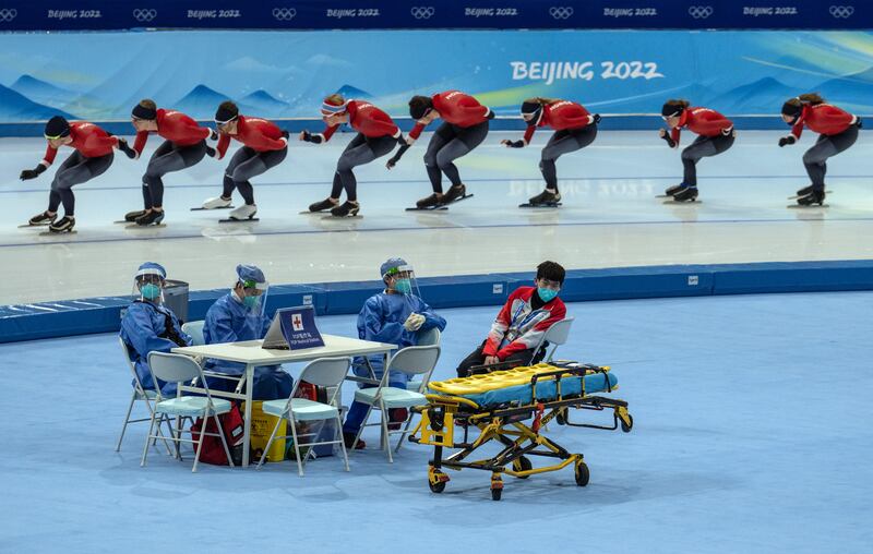 Medical staff in personal protective gear kit chat as Norwegian speed skaters take part in a practice session at the National Speed Skating Oval in Beijing. Getty