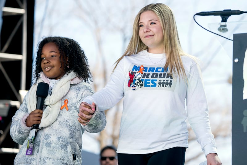 Jaclyn Corin, a student activist from Marjory Stoneman Douglas High School, holds hands with Yolanda Renee King, granddaughter of Martin Luther King Jr, at the 2018 March for Our Lives rally. AP